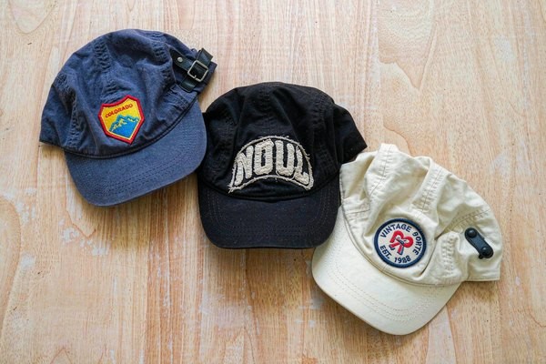 Hat patches branding: three baseball caps with custom embroidered patches on the front panels