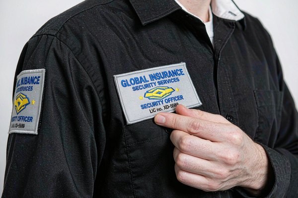 Security officer in black uniform wearing embroidered magnetic patches on the chest and shoulder, ready for quick role swaps
